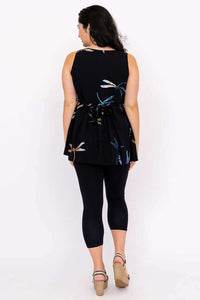 Back view of a woman in a black batik tank top with back ties and colorful leaf print