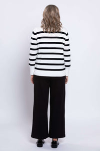 Back view of woman wearing black and tan striped sweater with ribbed hem