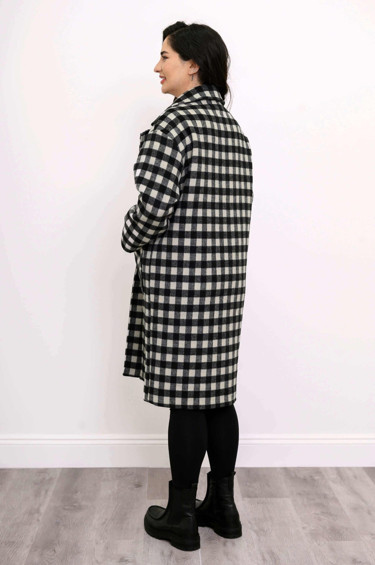 Back view of a woman wearing a black and white check patterned wool coat