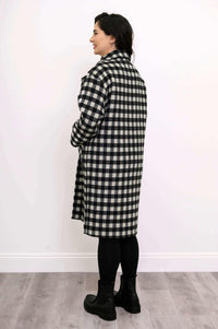 Back view of a woman wearing a black and white check patterned wool coat