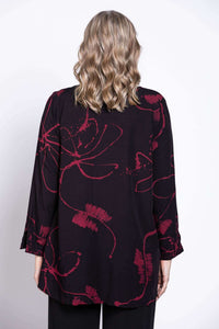 Back view of black blouse with berry floral design, model’s hair down