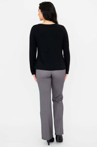 Woman showing the back of a black long sleeve boat neck top and gray check pants