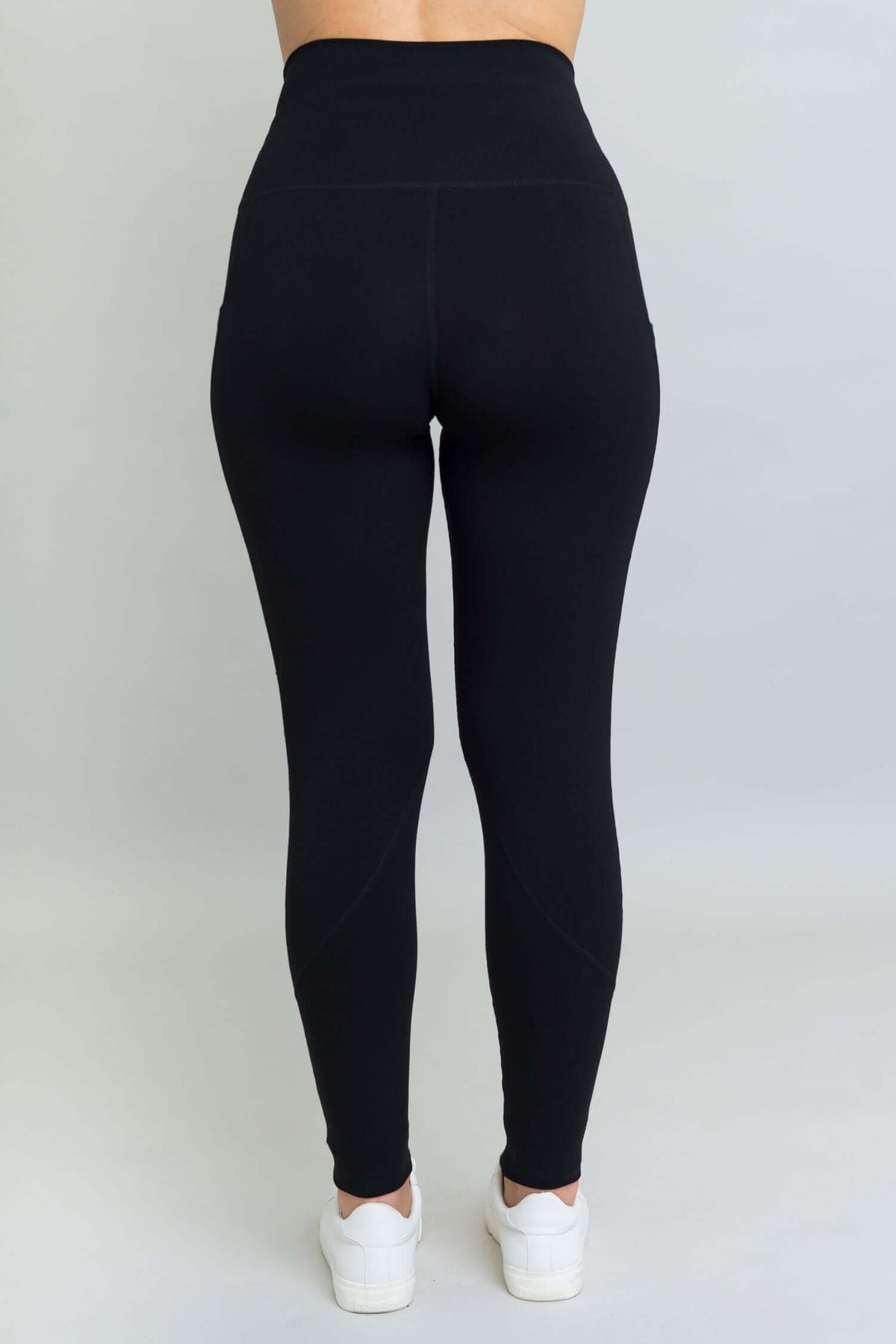 Back view of black fleece leggings showing high waistband and contoured seam details