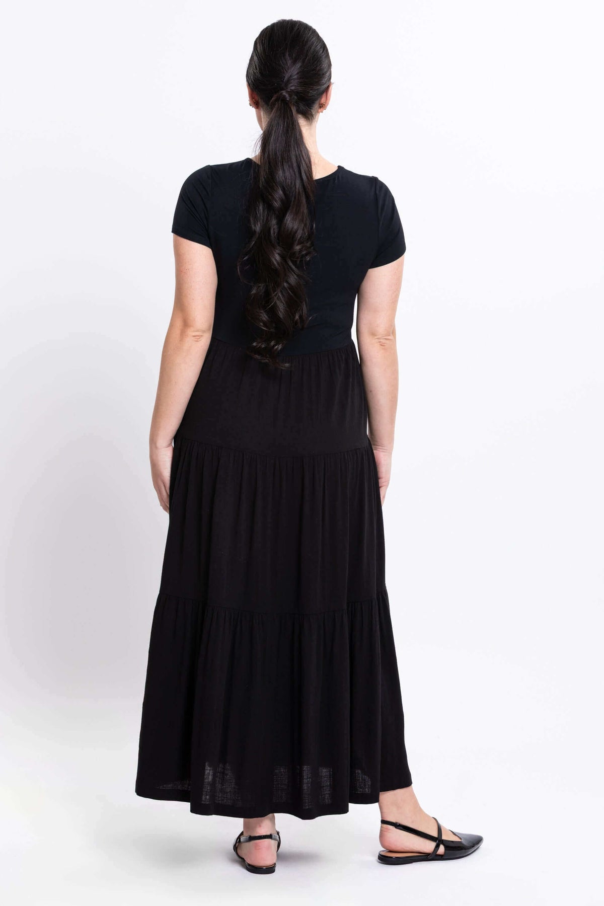 Back view of woman in black maxi dress displaying flowy skirt