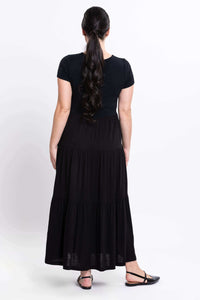 Back view of woman in black maxi dress displaying flowy skirt
