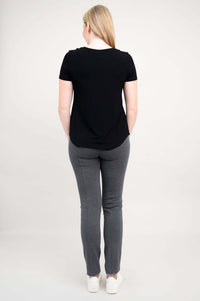 Back view of woman in black scoop neck tee and grey pants