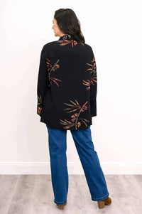 Back view of a woman wearing a black tunic with subtle floral designs