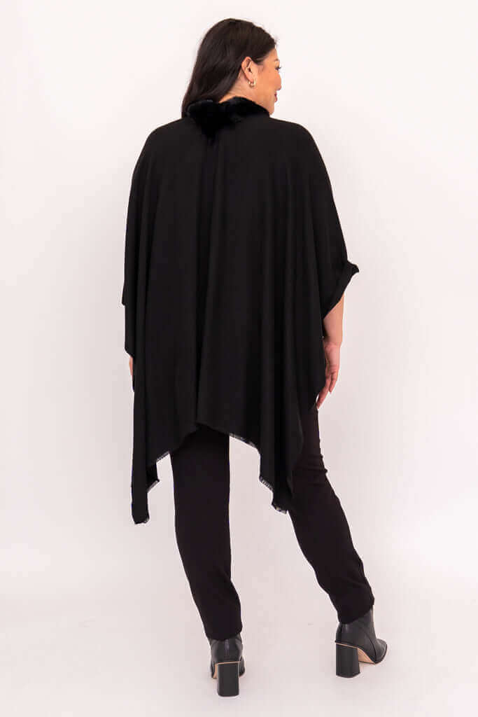 Back view of a woman wearing a black wrap with faux fur collar