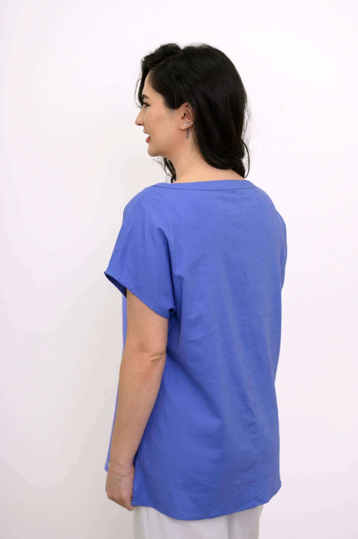 Back view of model in blue Aria Tee highlighting straight cut