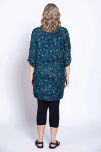 Back view of woman in blue and teal batik blouse with 3/4 length sleeves