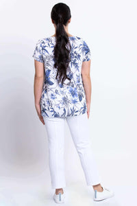 Back view of woman in blue and white floral top with white pants