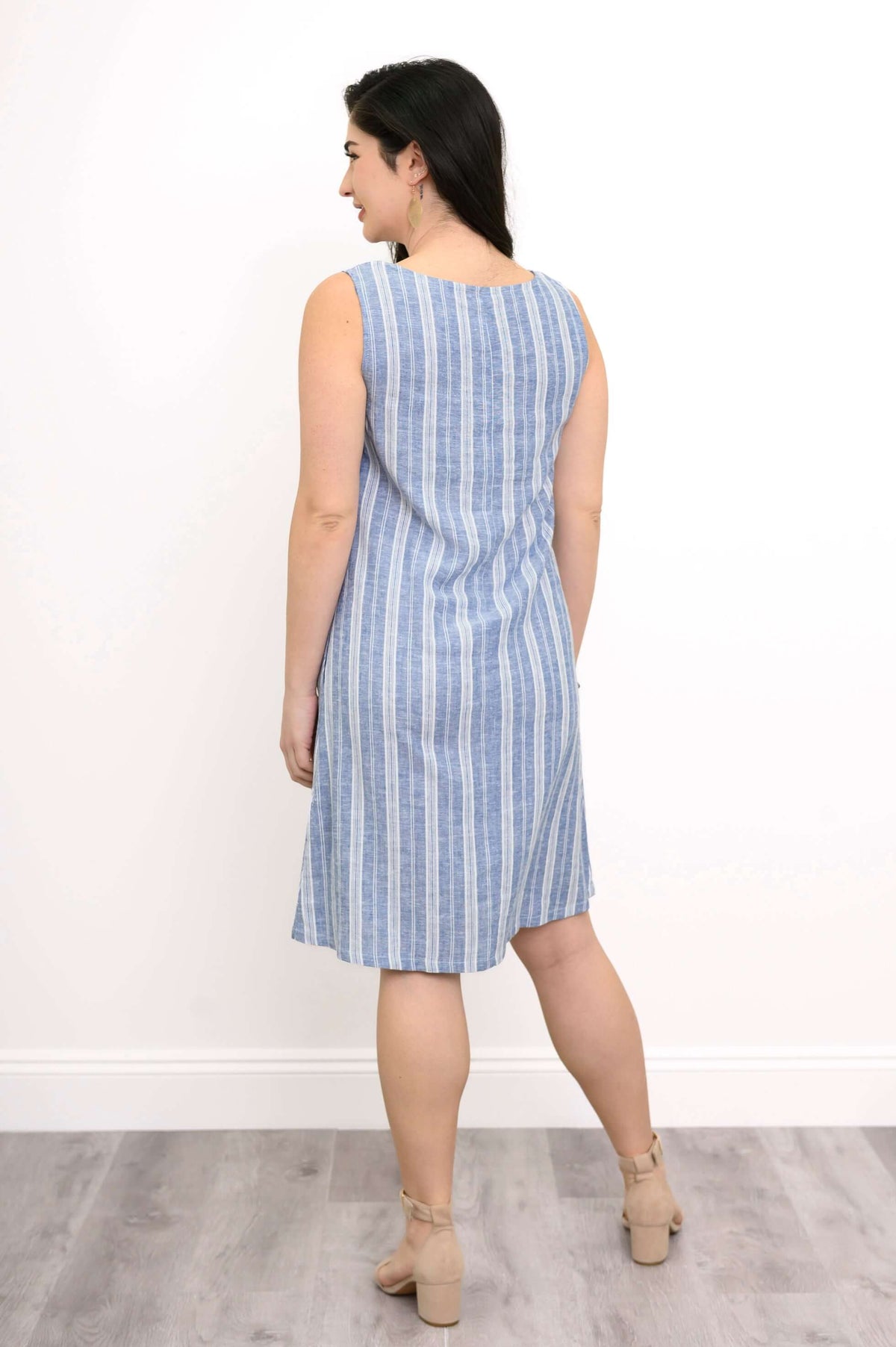 Back view of woman wearing a blue and white striped sleeveless shift dress