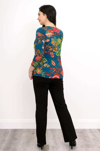 Woman showing back view of blue bamboo tee with colorful floral botanical print