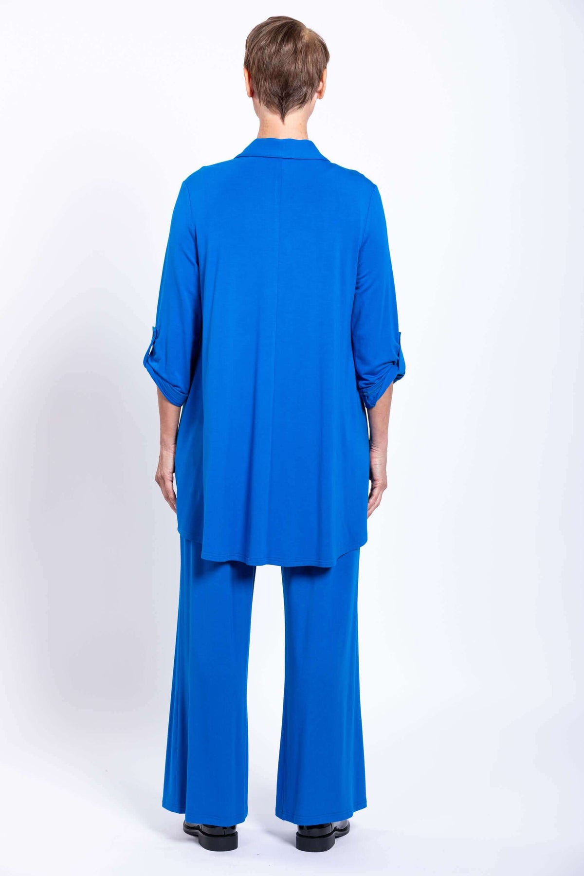 Rear view of woman in blue blouse-jacket and matching wide-leg pants
