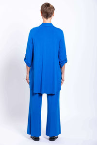 Rear view of woman in blue blouse-jacket and matching wide-leg pants