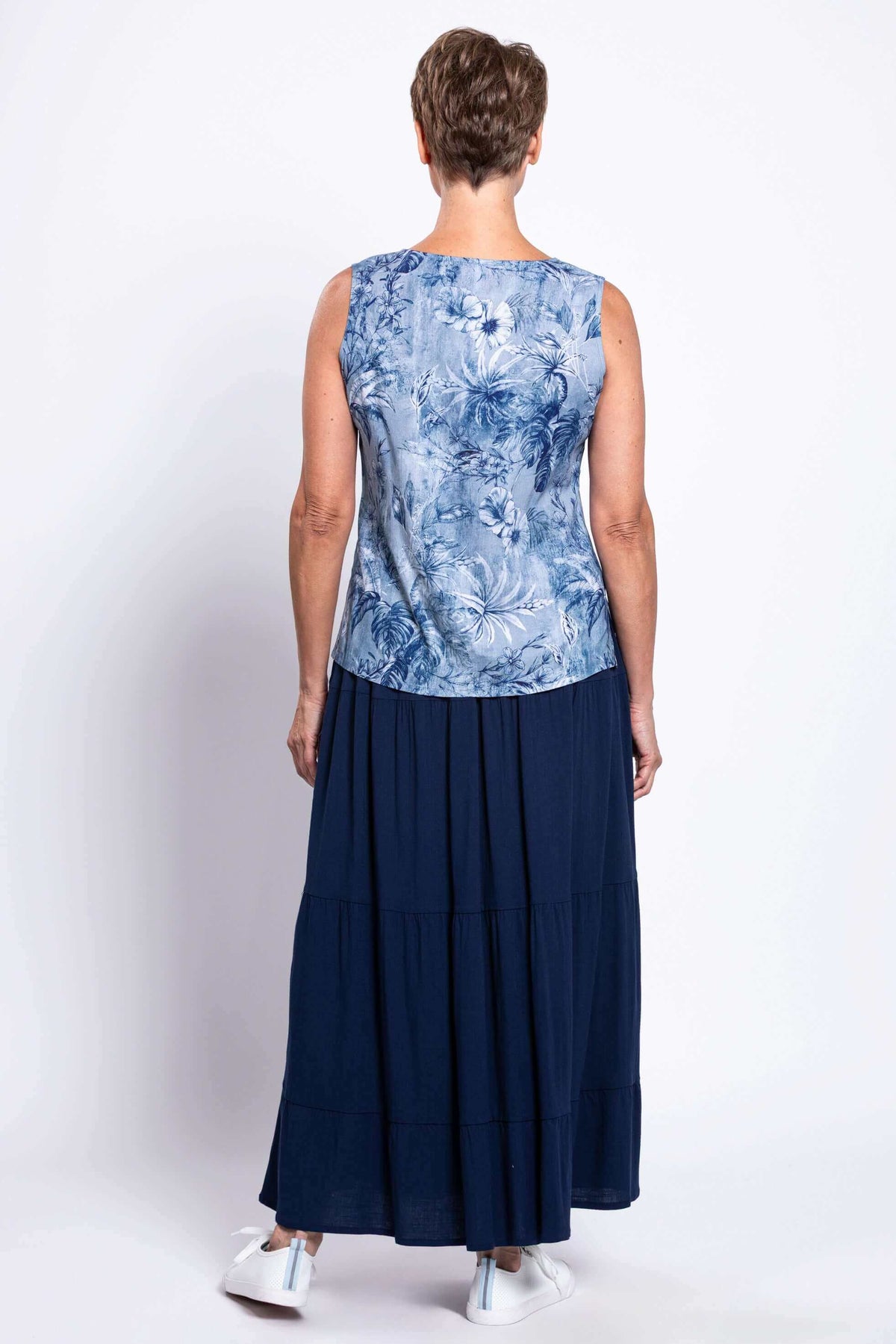 Back view of blue botanical tank top and navy maxi skirt on model
