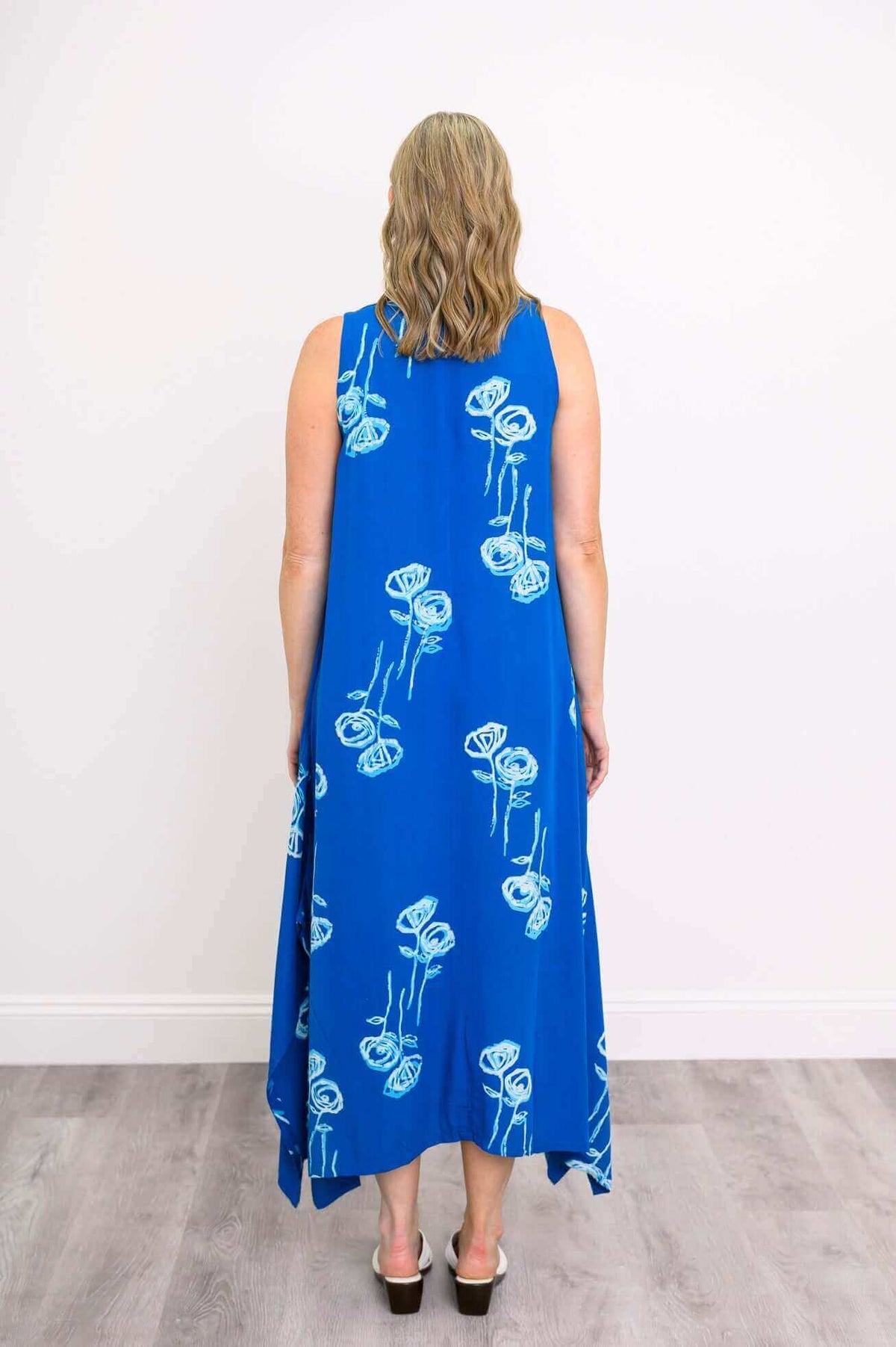 Back view of model in a blue floral dress with square neckline