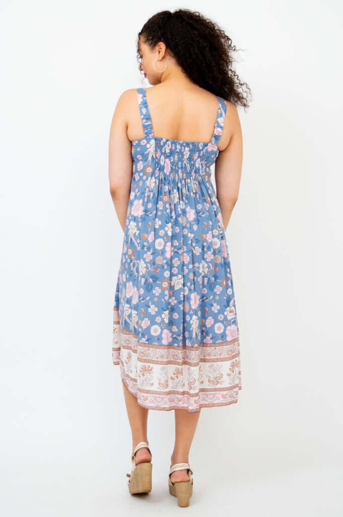 Back view of woman in a blue floral dress with shirred bodice