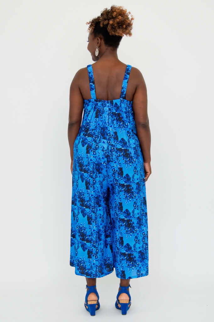 Back view of blue floral jumpsuit showcasing elastic straps