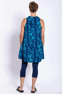 Back view of model wearing sleeveless blue A-line tank with bright floral print