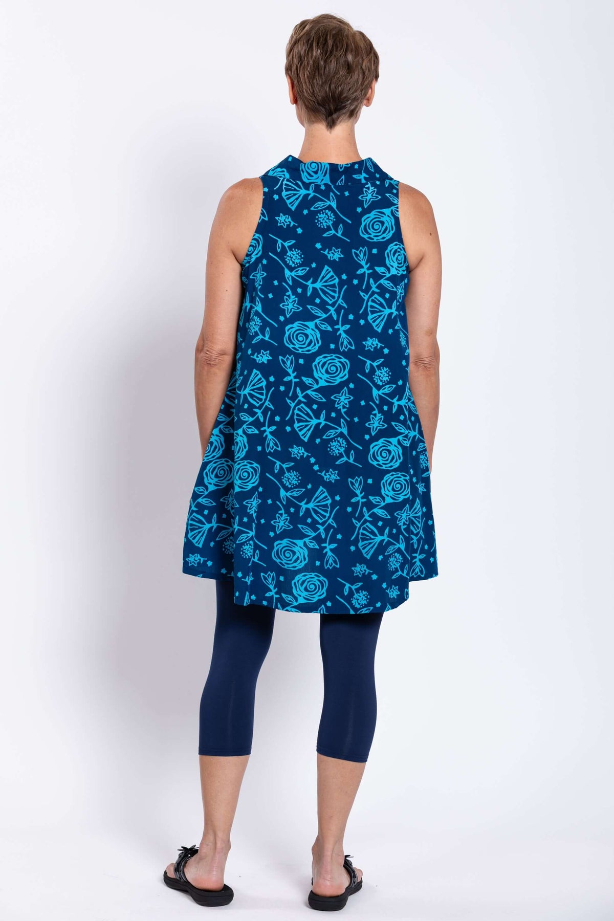 Back view of woman wearing blue floral sleeveless button-up tank dress