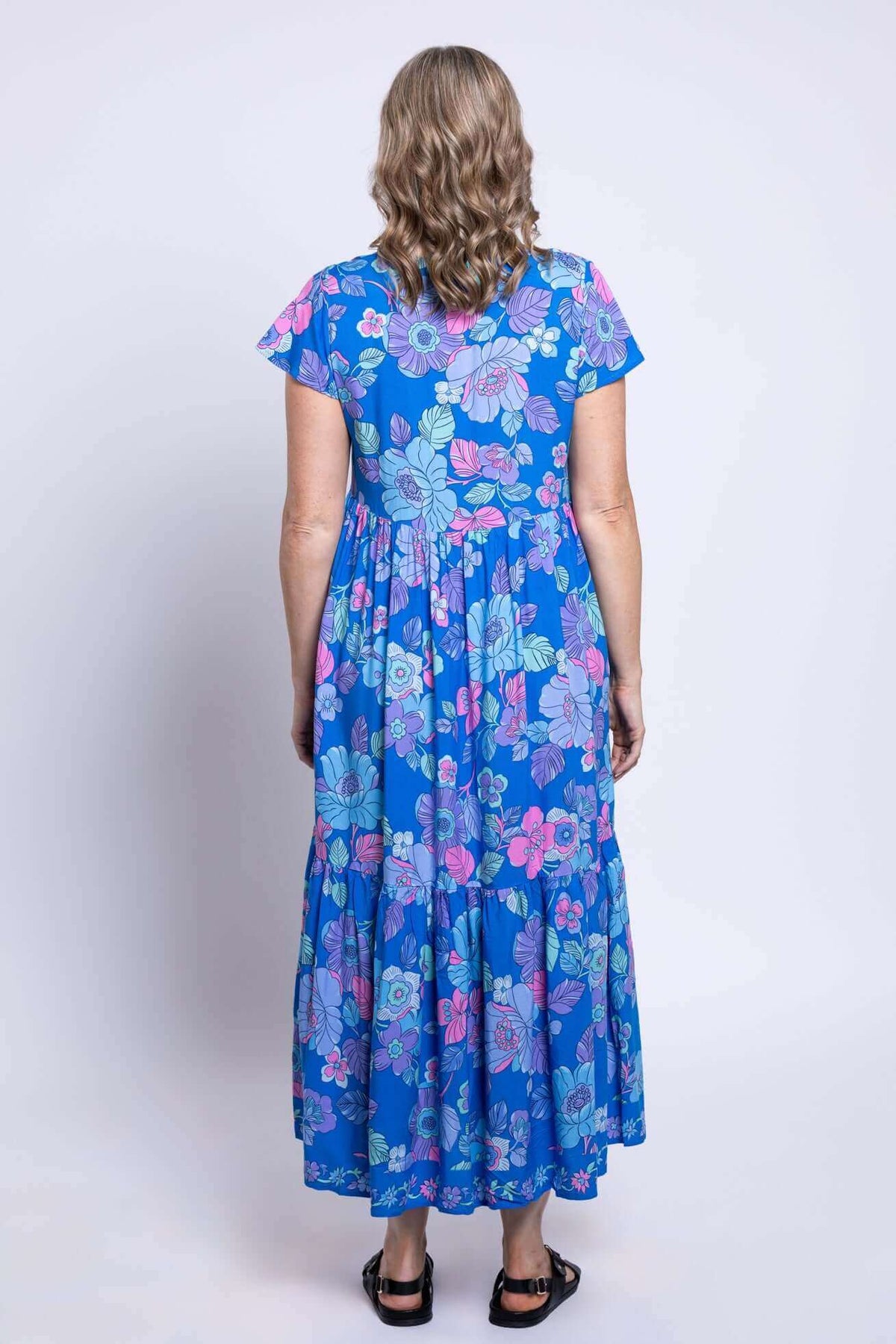 Back view of the blue floral tiered Sharpie Dress showing flutter sleeves and flowy skirt