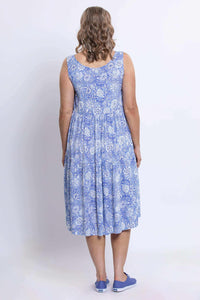 Rear view of a woman in a blue floral tiered dress and blue sneakers