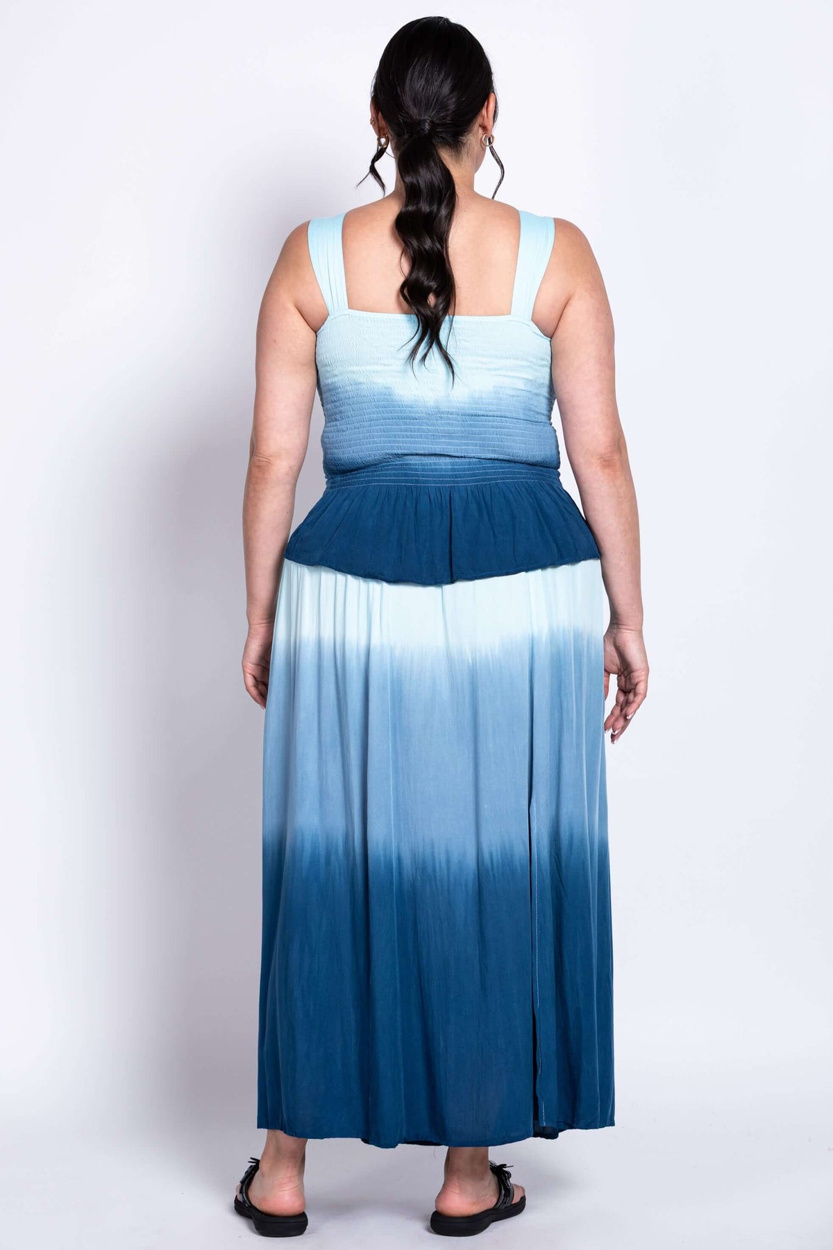 Back view of a blue ombre maxi dress showing smocked upper back and flared skirt