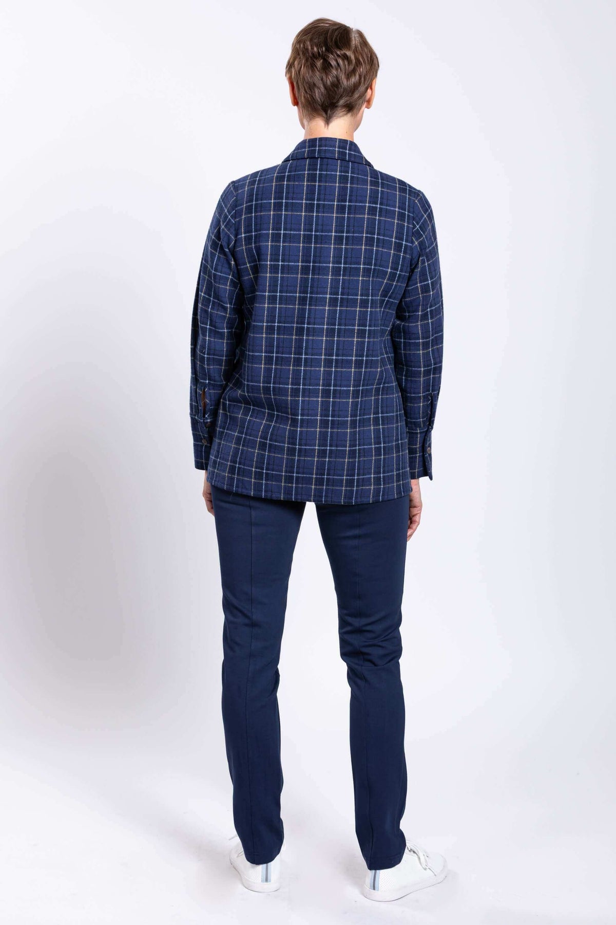 Back view of woman wearing blue plaid cotton jacket and navy pants