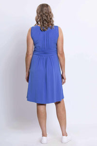 Back view of a woman wearing a blue ruched dress showing gathered fabric and fit