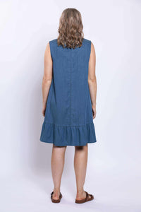 Back view of woman wearing a sleeveless blue dress with ruffle hem, showing full back
