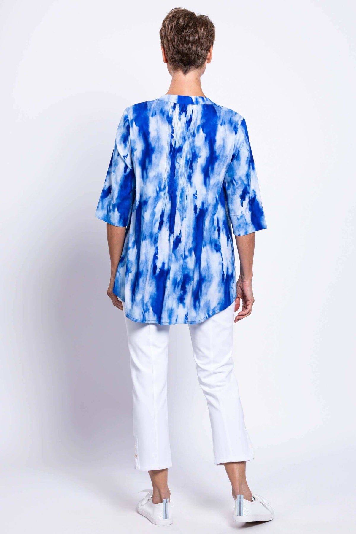 Back view of a woman wearing the blue tie-dye Margate blouse with pintuck details