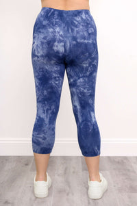 Back view of blue tie-dye capri leggings with white sneakers