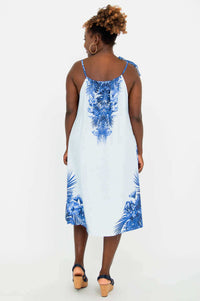 Back view of woman in light blue dress with blue tropical print border and tie shoulder strap