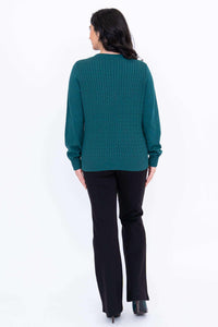 Back view of model in teal cable knit crew neck sweater