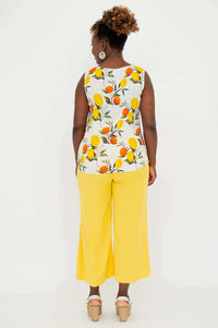 Back view of model wearing citrus print V-neck tank with yellow pants