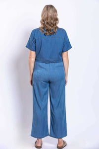 Back view of cropped denim jacket worn with matching wide-leg pants