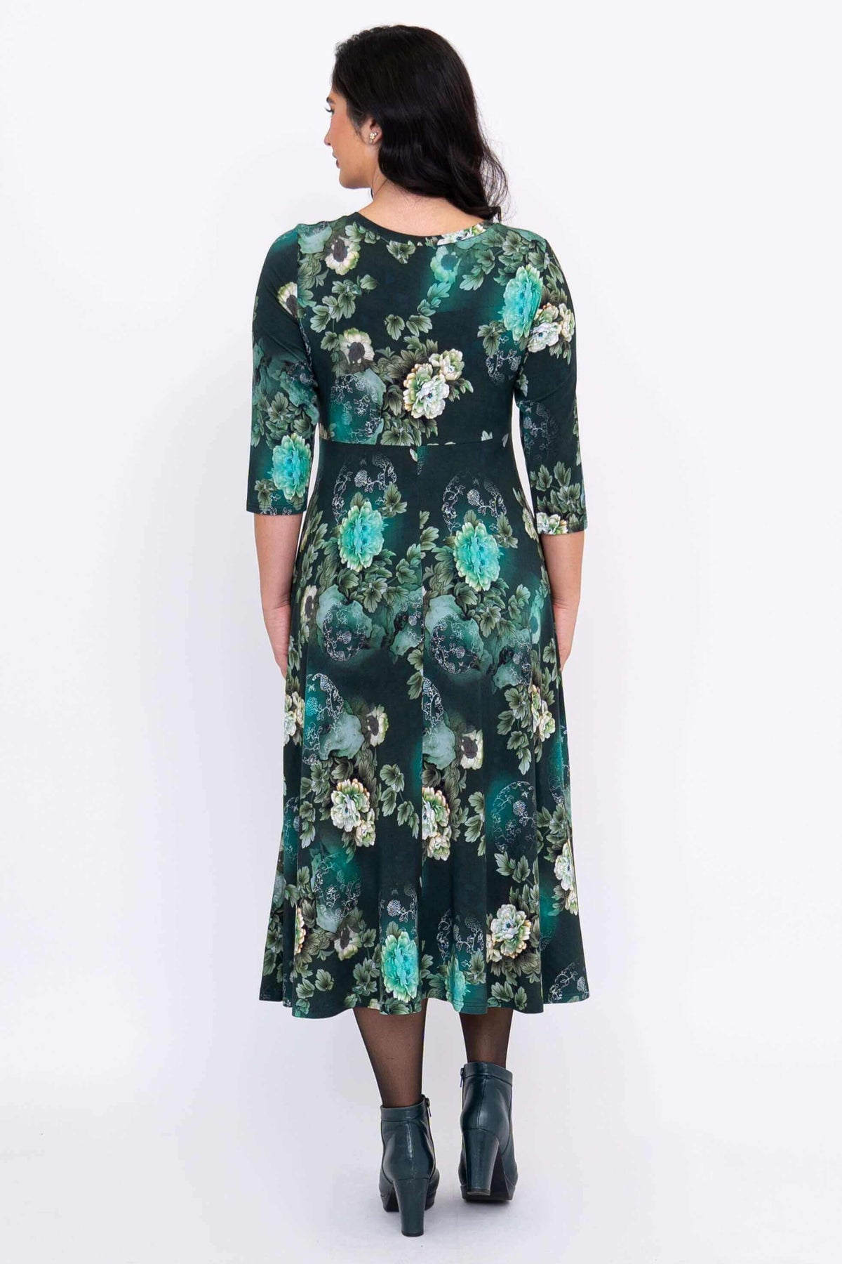Back view of woman in a green floral midi dress highlighting the floral pattern and relaxed fit
