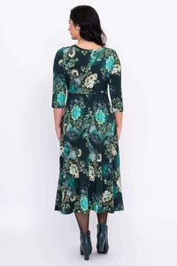 Back view of woman in a green floral midi dress highlighting the floral pattern and relaxed fit