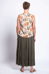 Back view of woman wearing a floral V-neck sleeveless cropped tank top and olive skirt