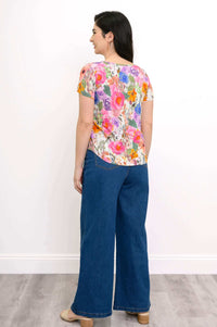 Back view of woman wearing floral print short sleeve top and wide-leg jeans