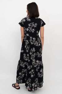 Back view of a black and white floral tiered maxi dress with flutter sleeves