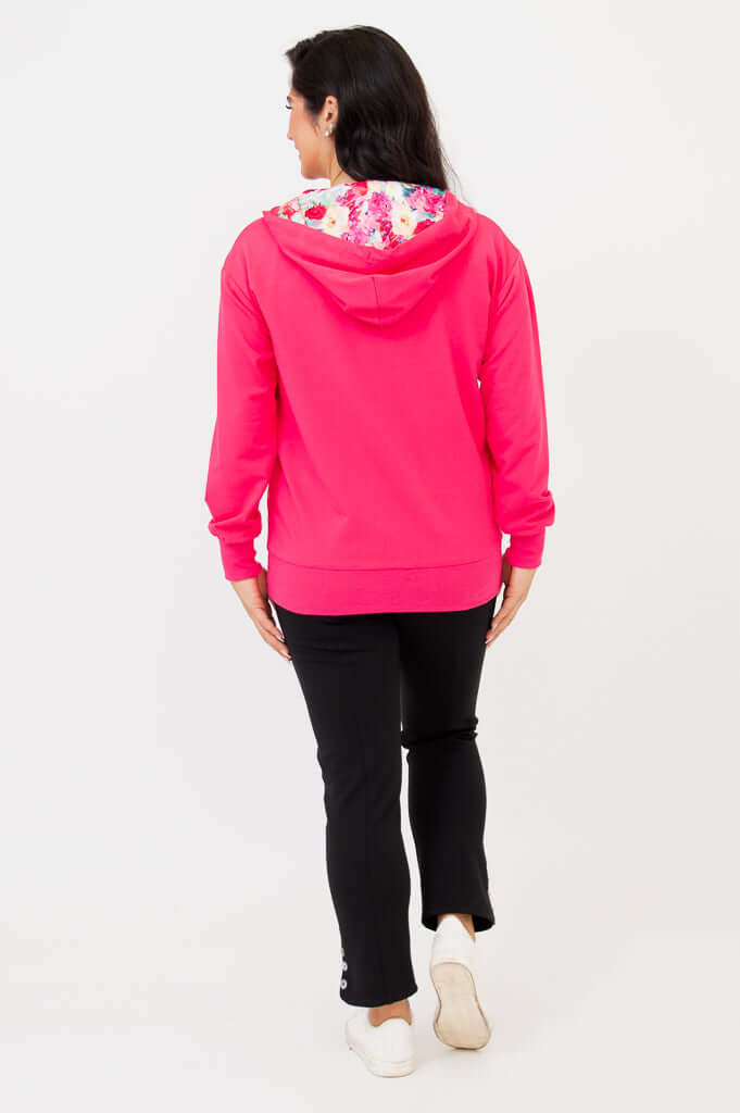 Back view of woman in fuchsia hoody with floral-printed hood lining