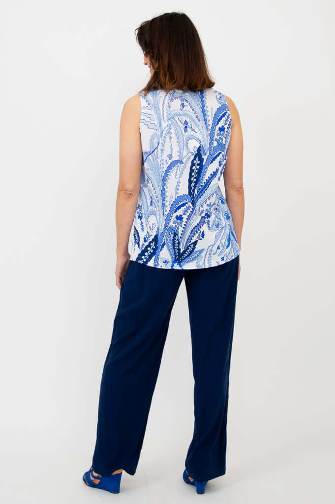 Back view of woman in blue and white paisley print tank top and navy pants