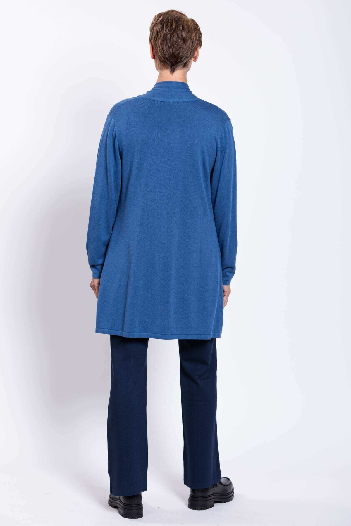 Back view of woman wearing a long blue cardigan, showing length and fit