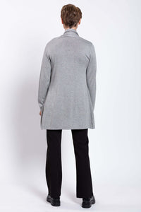 Back view of a woman in a long grey cardigan sweater, black pants and boots