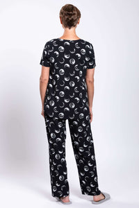 Back view of woman in black pajama set with all-over moon phase print