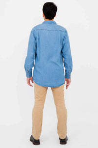 Back view of man in light blue button-up shirt and tan pants