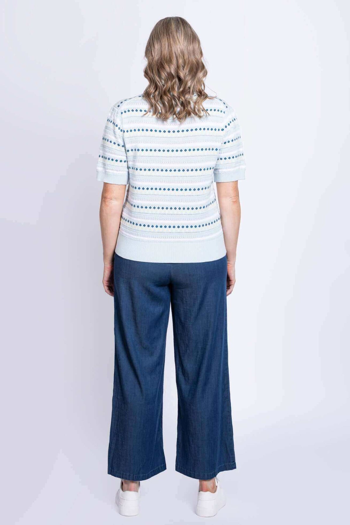 Back view of second model wearing Sweater with blue wide-leg pants