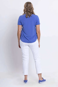 Back view of woman in blue scoop neck tee and white pants, showing curved hem